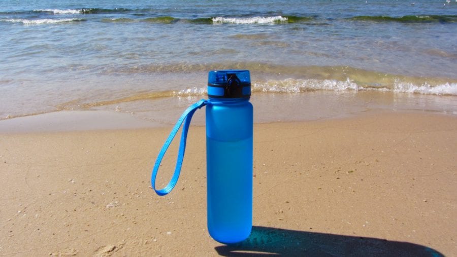 blue water bottle on a beach