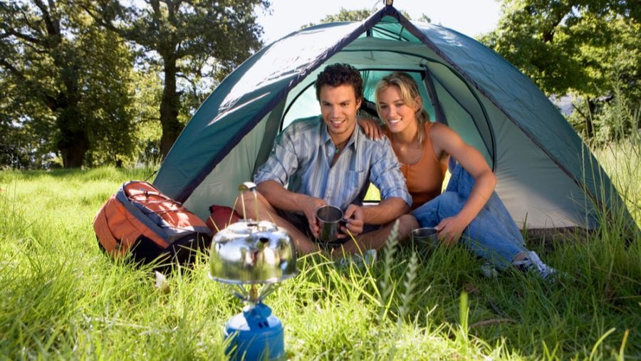 couple heating up water on a camping stove