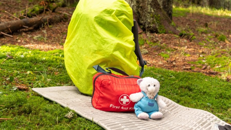first aid kit sitting next to a hiking backpack