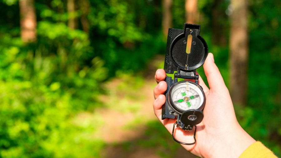 hiker with hiking compass in the woods