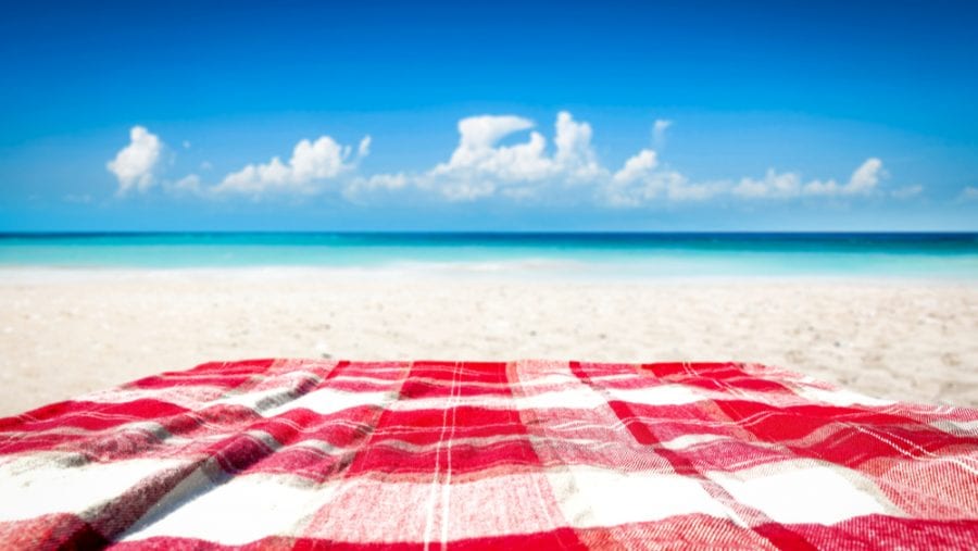 red and white blanket on a white beach