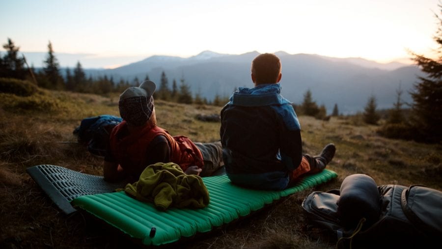 two hikers on a sleeping pad