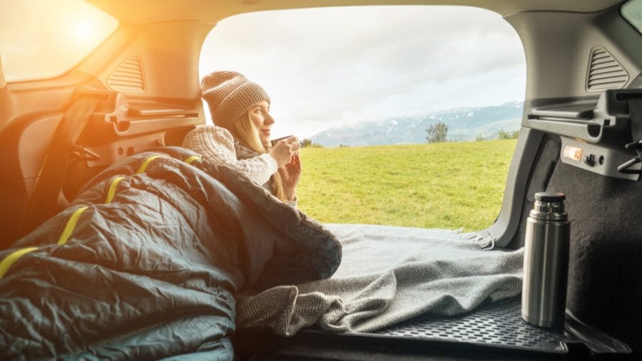 woman relaxing on a sleeping bag inside the car