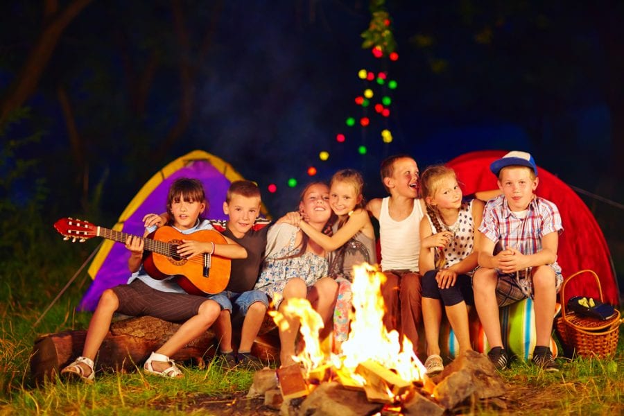 Kids playing around a campfire