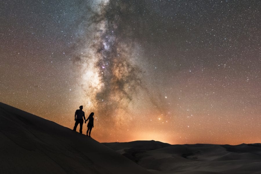 Romantic couple stargazing under the milky way galaxy