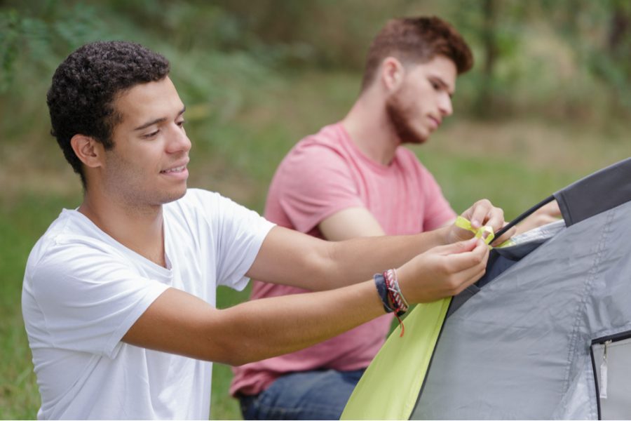 two men tying knots for their tent